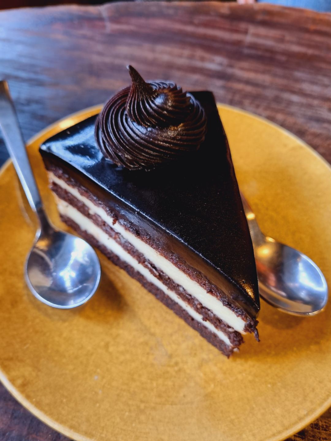 A slice of dark chocolate truffle cake on a plate