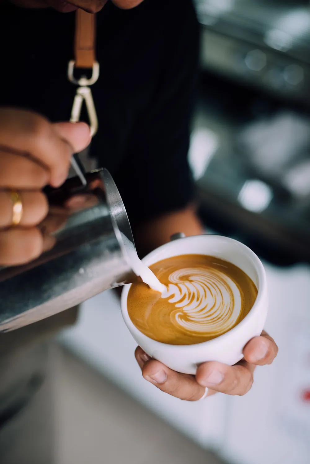 Barista pouring latte art into a cappuccino
