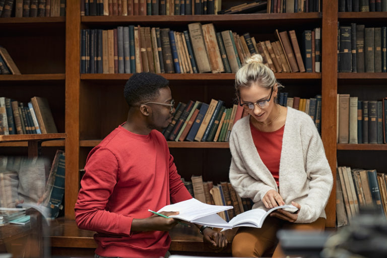 Two students studying together in a library