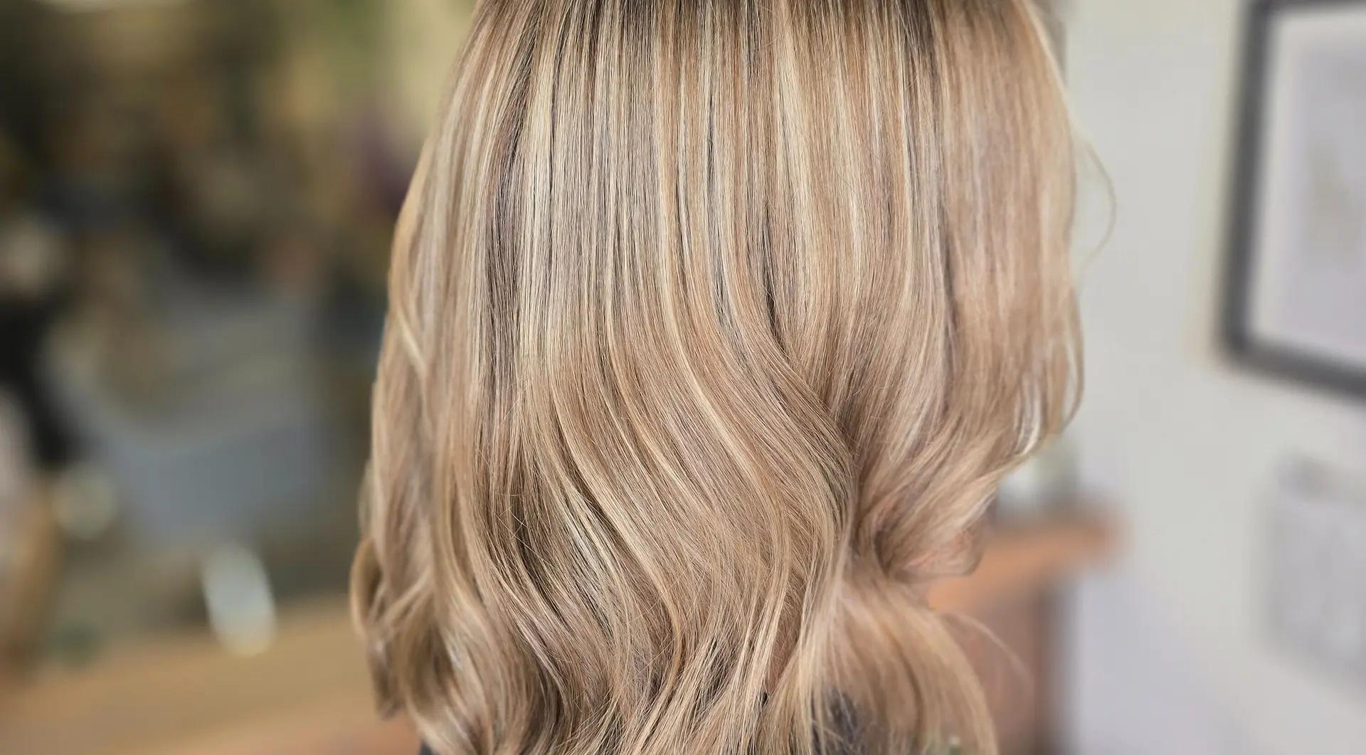 A stylist finishing a client's hair inside the salon