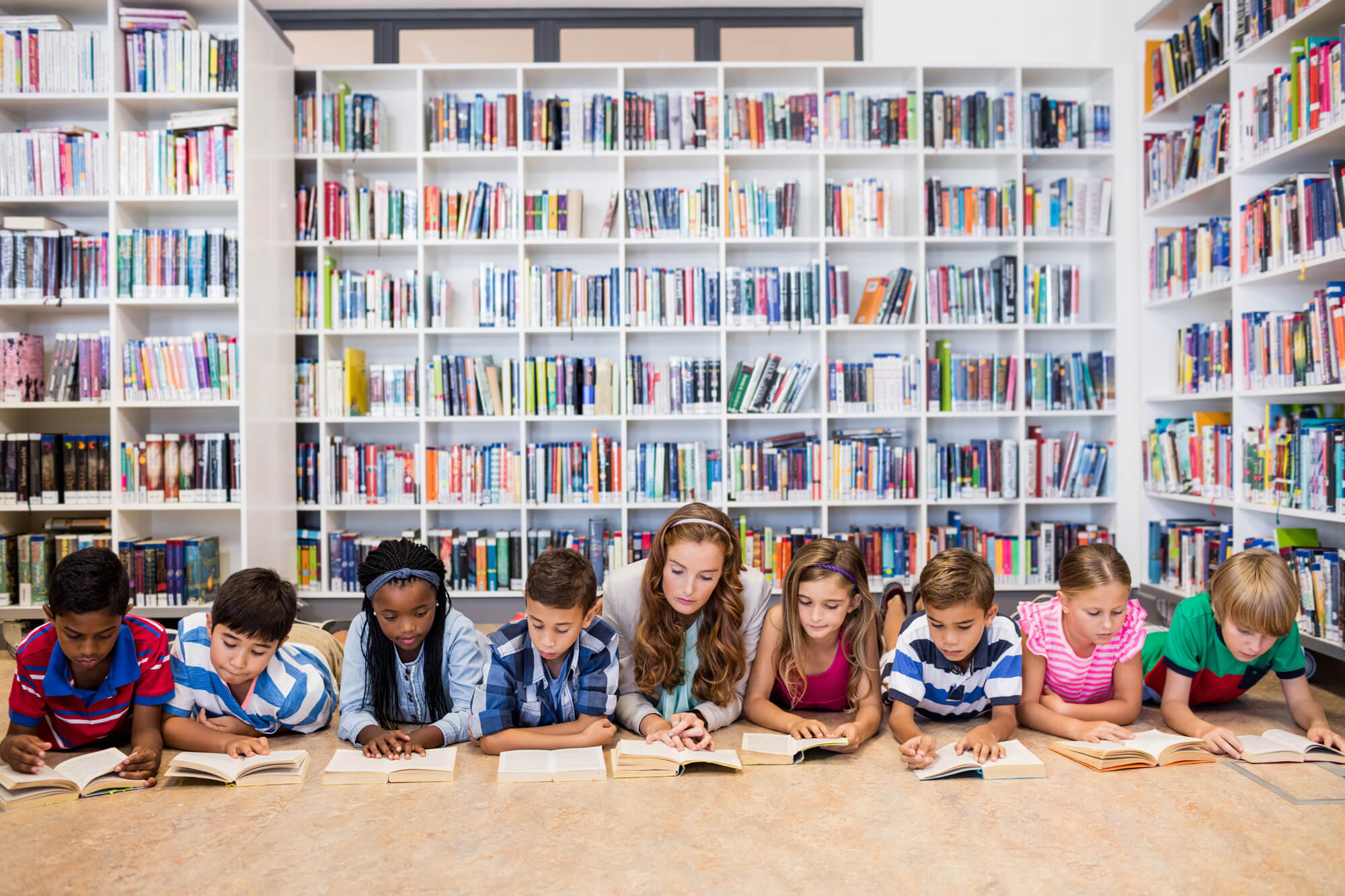 Children reading together on the floor of the school library